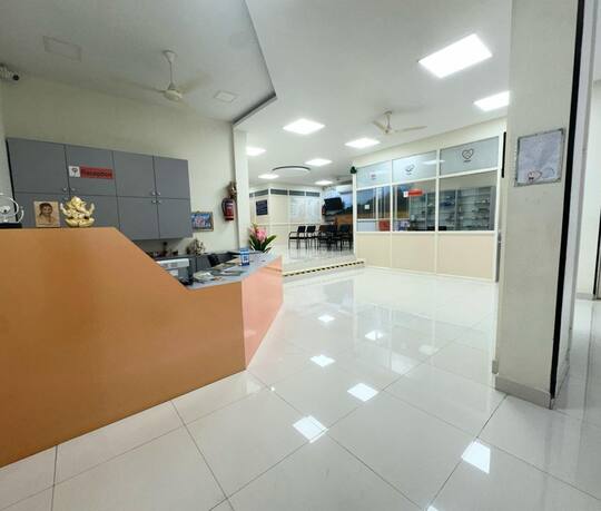ஜனனம் ஃபெர்ட்டிலிட்டி சென்டர், திருப்போரூரின் வரவேற்பு மேசை; பின்னால் காத்திருக்கும் பகுதியும் மருந்தகமும்